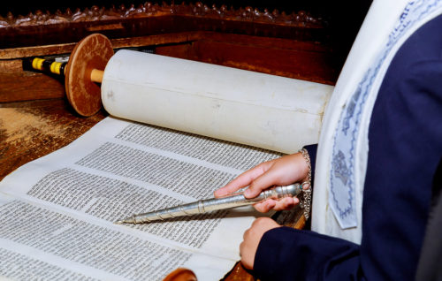 10 NOVEMBER 2018 New York NY Jewish man dressed in ritual clothing Hand of boy reading the Jewish Torah at Bar Mitzvah Bar Mitzvah Torah reading